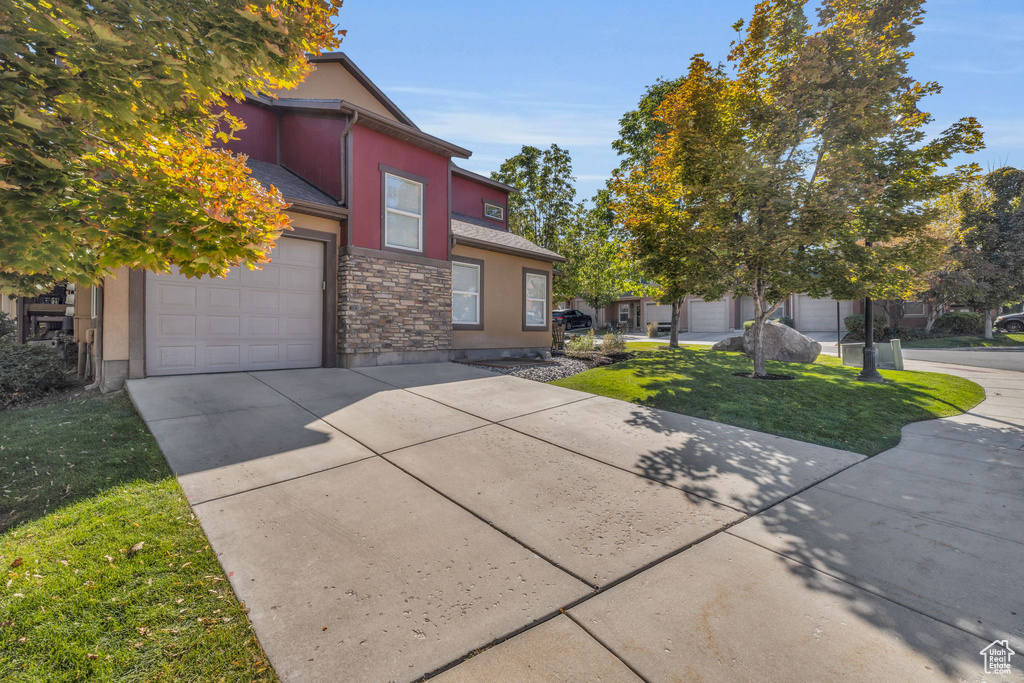 View of front of property featuring a front yard and a garage