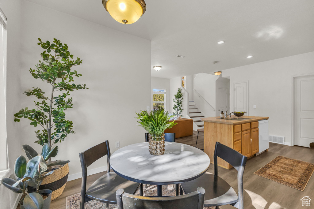 Dining space with sink and dark hardwood / wood-style flooring