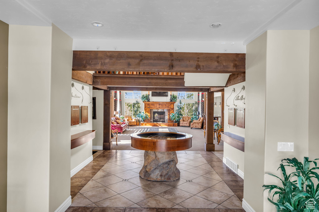 Interior space featuring tile patterned floors and beam ceiling