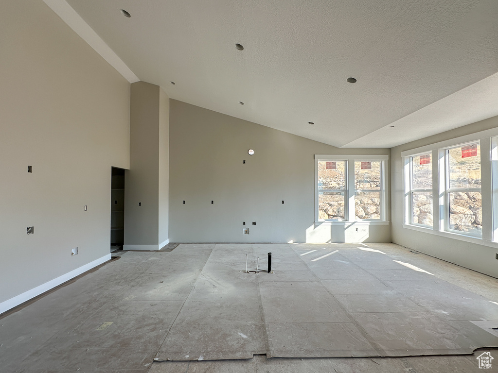 Spare room featuring vaulted ceiling and a textured ceiling