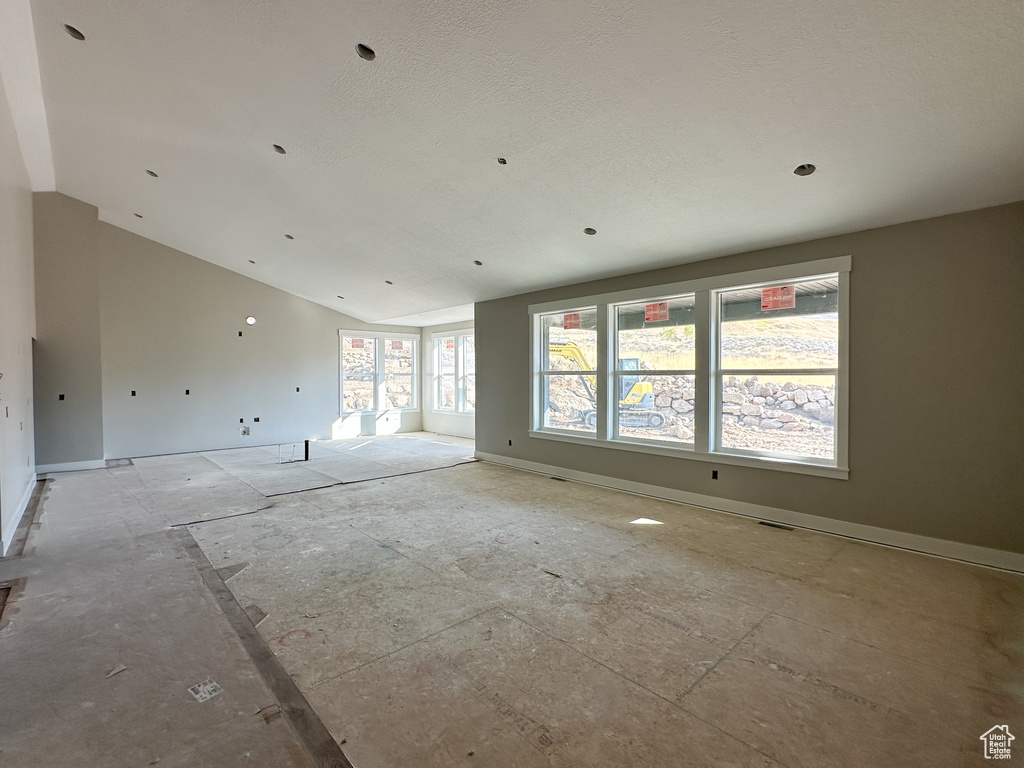 Spare room with lofted ceiling and a healthy amount of sunlight