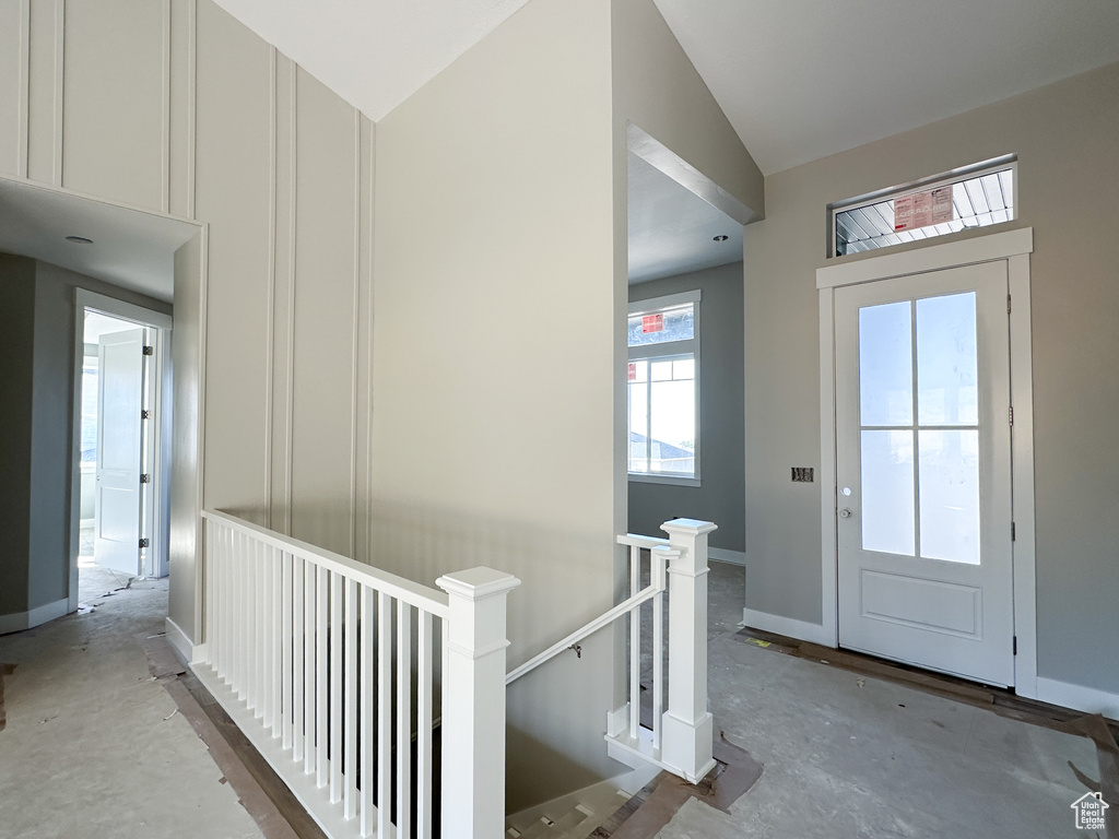 Entryway with vaulted ceiling and concrete flooring