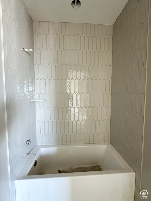 Bathroom featuring a bathing tub and a textured ceiling