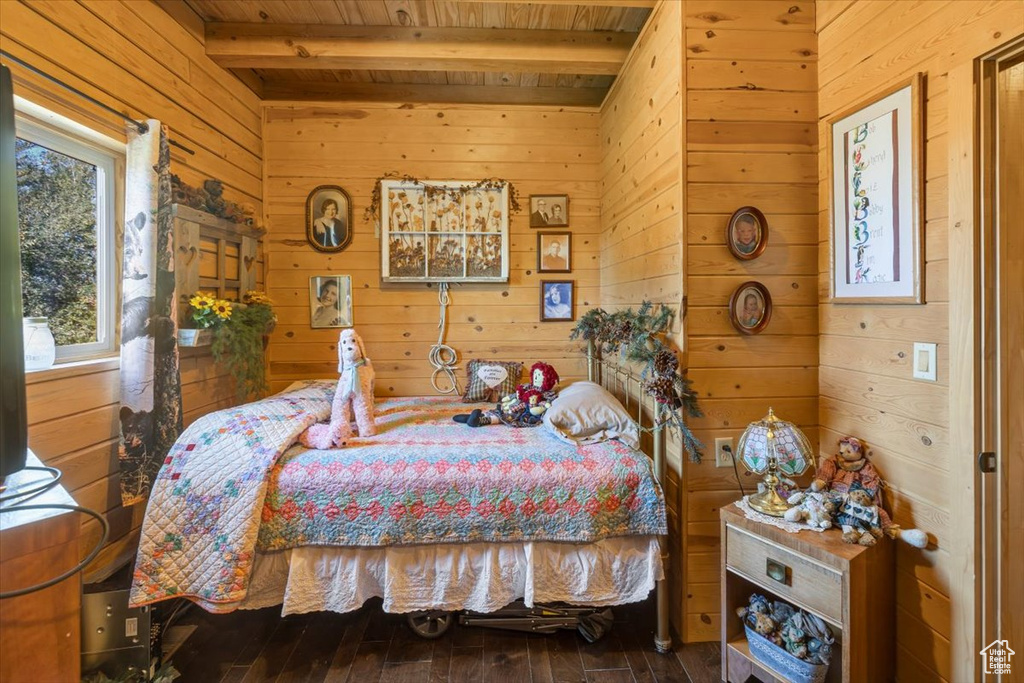 Bedroom featuring beamed ceiling, wooden walls, wooden ceiling, and wood-type flooring