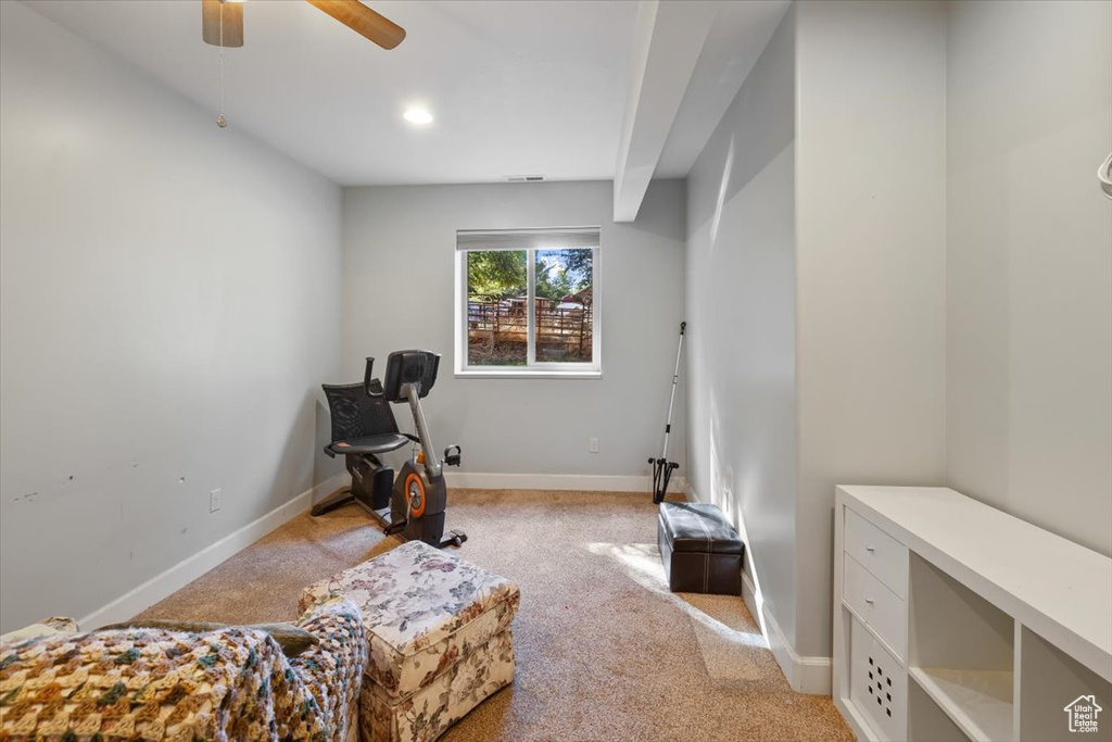 Living area with ceiling fan and light colored carpet