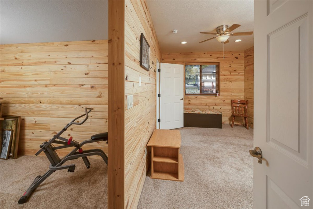 Hall with wood walls and carpet flooring