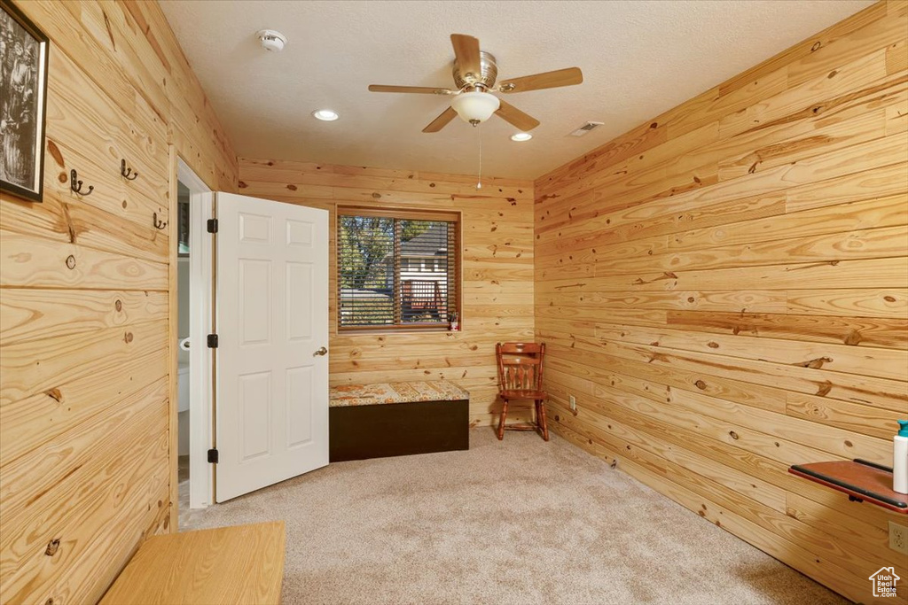 Interior space with ceiling fan and wood walls