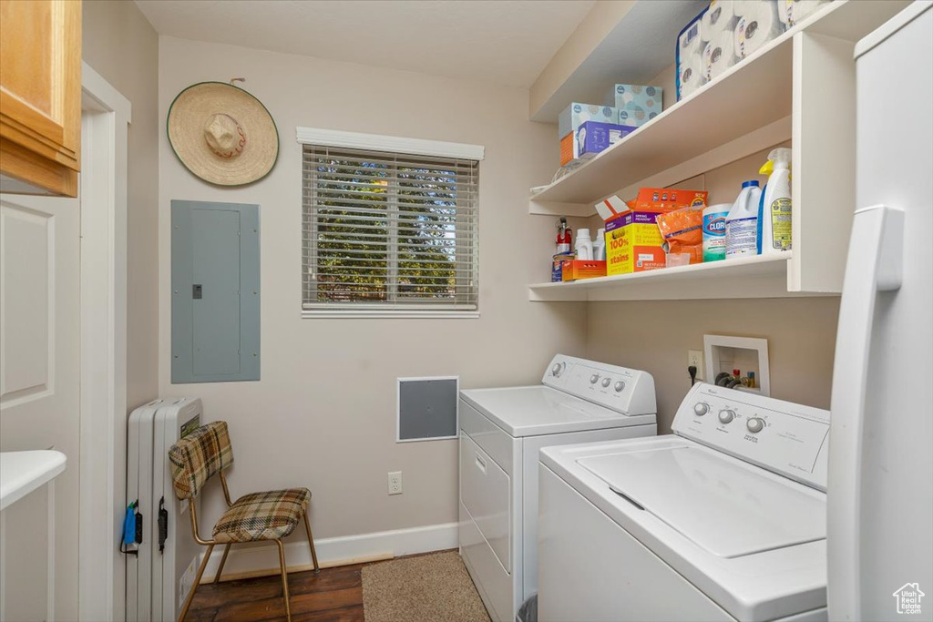 Washroom featuring washer and clothes dryer, radiator, electric panel, and dark hardwood / wood-style floors