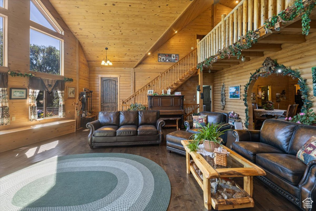 Living room with wood walls, dark wood-type flooring, wooden ceiling, and a healthy amount of sunlight