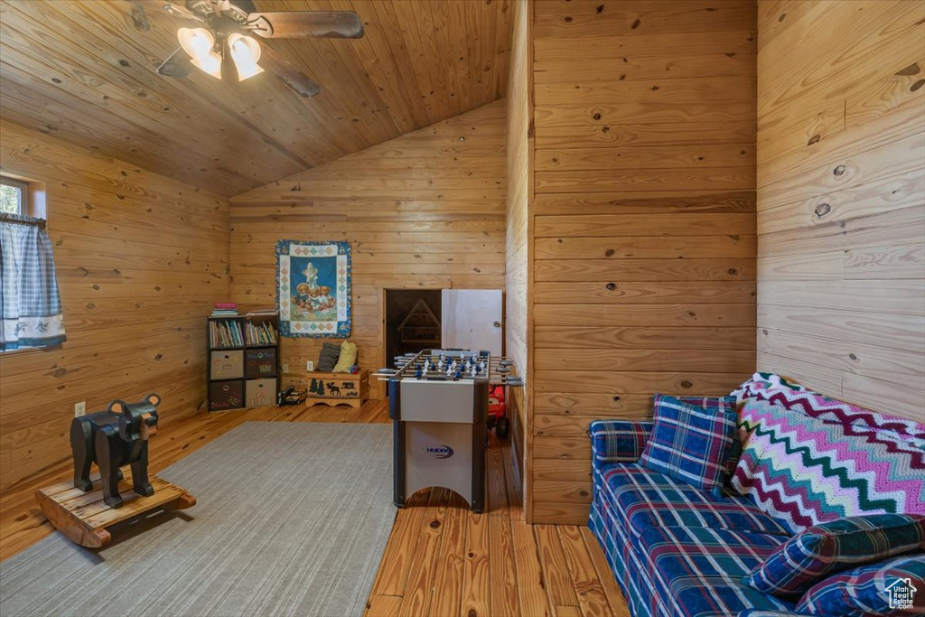 Sitting room featuring lofted ceiling, wood walls, wooden ceiling, and hardwood / wood-style flooring