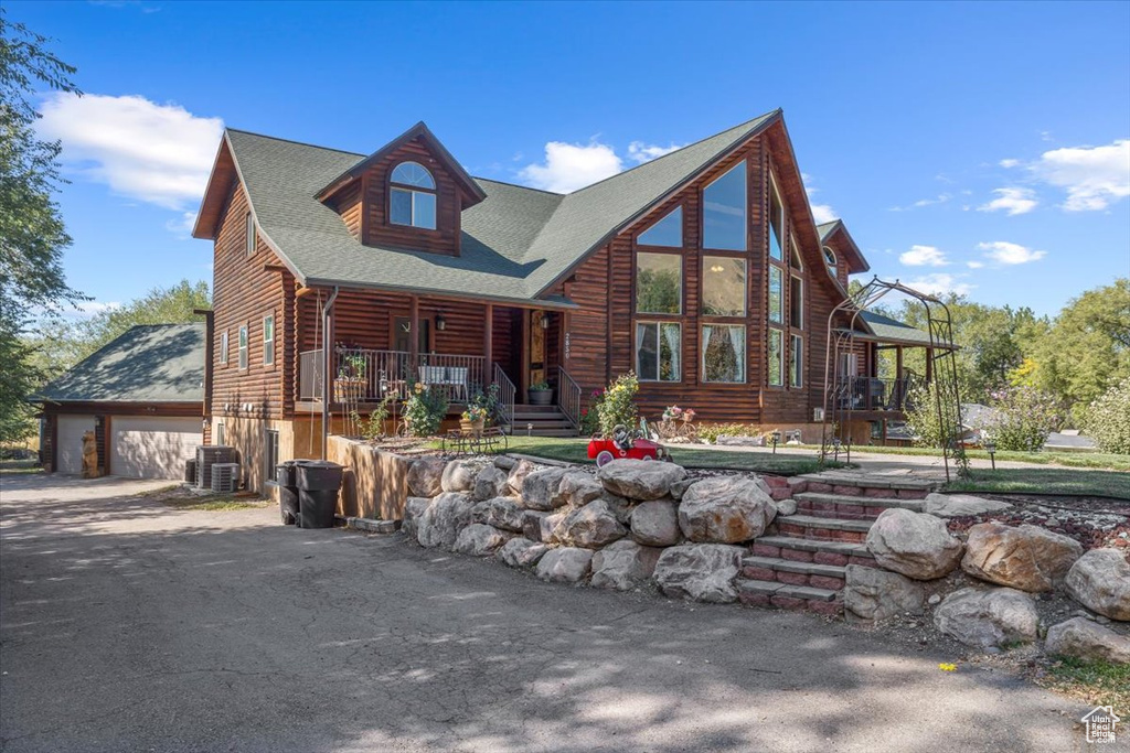 Log home featuring a porch and central air condition unit