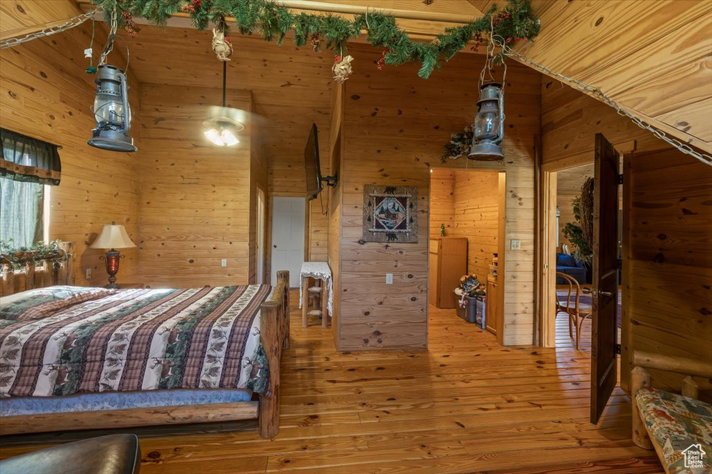 Bedroom featuring wood-type flooring and wooden walls