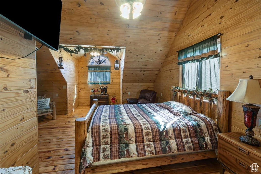 Bedroom with wood ceiling, wood walls, vaulted ceiling, and wood-type flooring