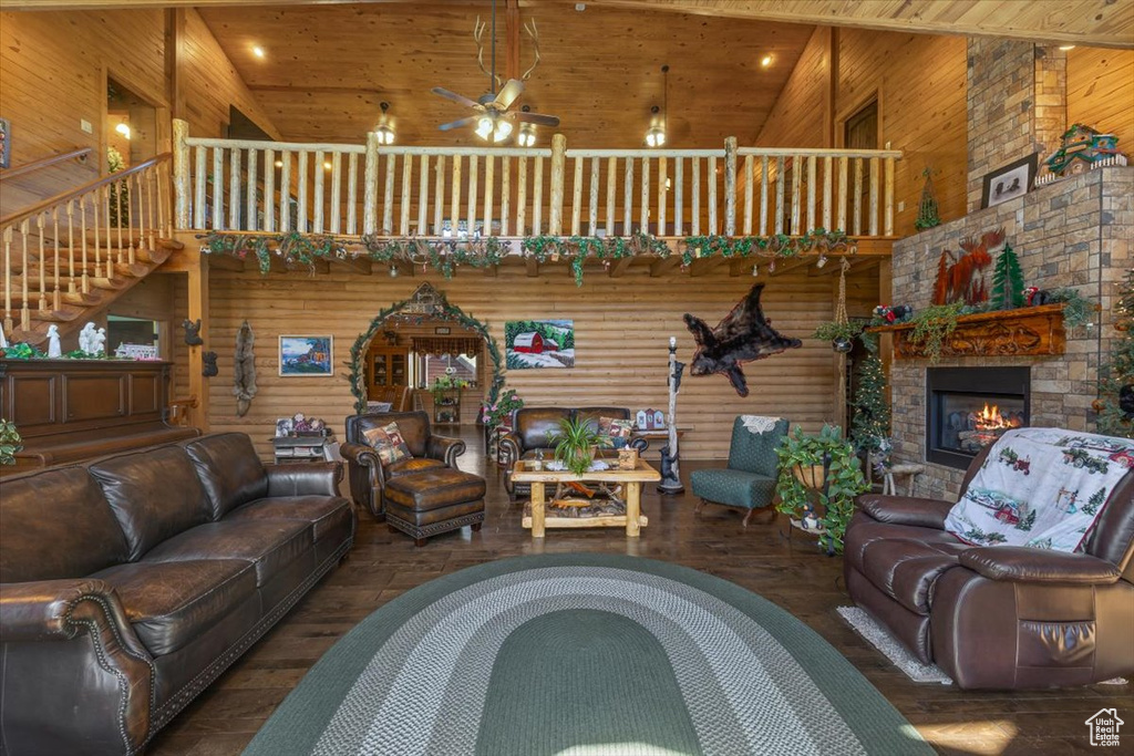 Living room featuring wood ceiling, a fireplace, dark hardwood / wood-style flooring, and high vaulted ceiling