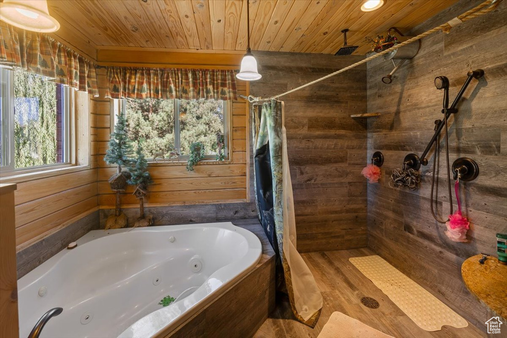 Bathroom featuring independent shower and bath, hardwood / wood-style flooring, wood walls, and wooden ceiling