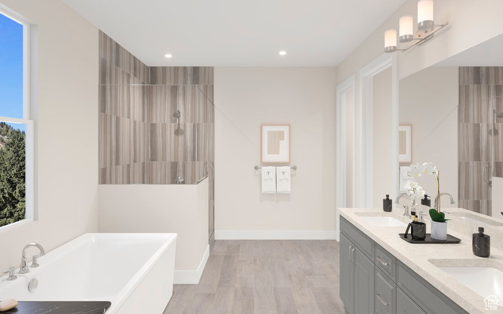 Bathroom featuring vanity, wood-type flooring, and shower with separate bathtub