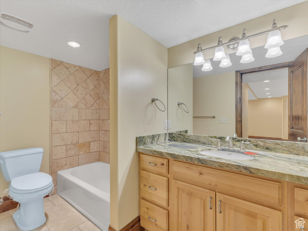 Full bathroom with vanity, tub / shower combination, a textured ceiling, tile patterned floors, and toilet