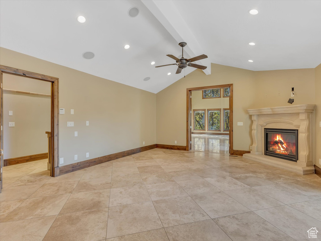 Unfurnished living room featuring vaulted ceiling with beams and ceiling fan