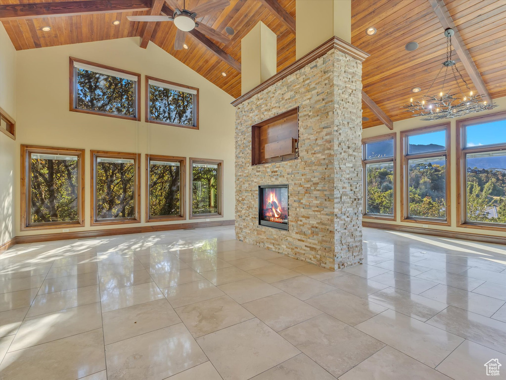 Unfurnished living room with plenty of natural light, beam ceiling, high vaulted ceiling, and wooden ceiling