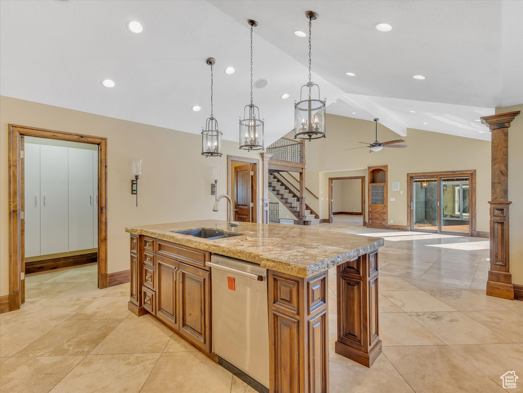 Kitchen with an island with sink, sink, hanging light fixtures, vaulted ceiling, and dishwasher