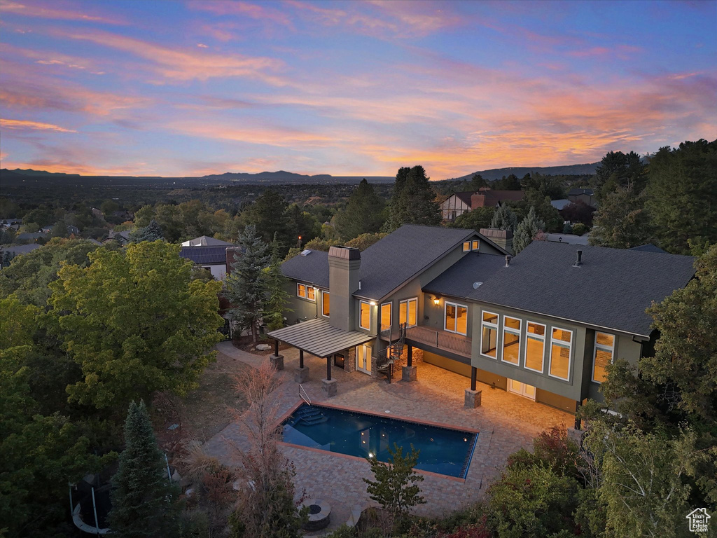 Pool at dusk featuring a patio area