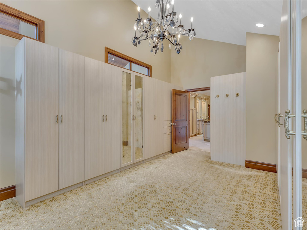 Unfurnished bedroom with an inviting chandelier and a high ceiling