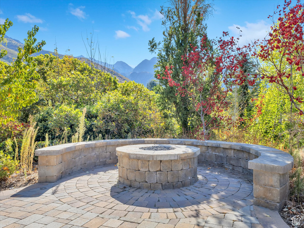 View of patio with a mountain view and a fire pit