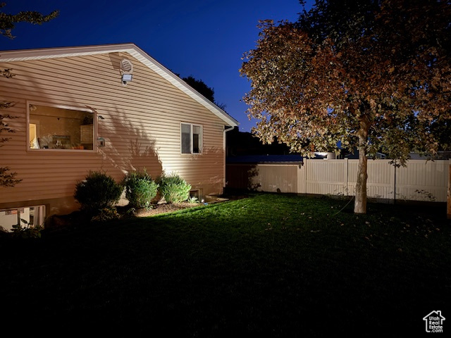 Property exterior at twilight featuring a yard