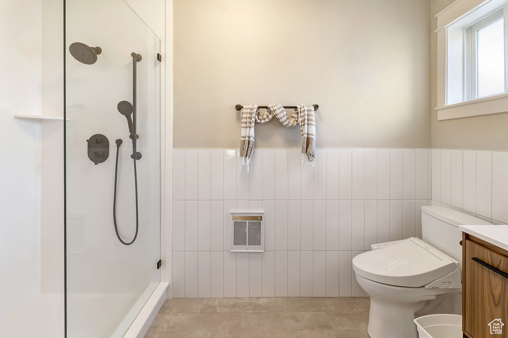 Bathroom with vanity, toilet, heating unit, walk in shower, and tile patterned flooring