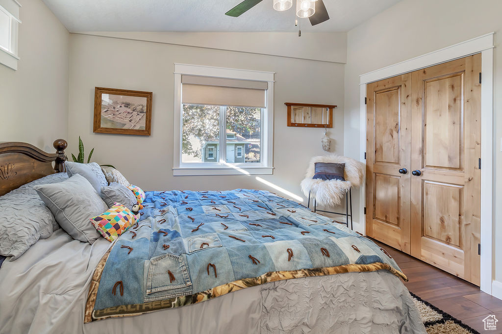 Bedroom featuring a closet, vaulted ceiling, dark hardwood / wood-style flooring, and ceiling fan