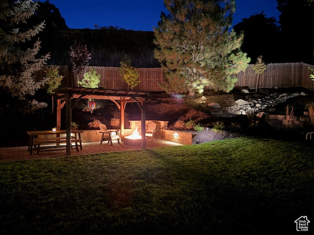 Yard at night with a patio area and a pergola