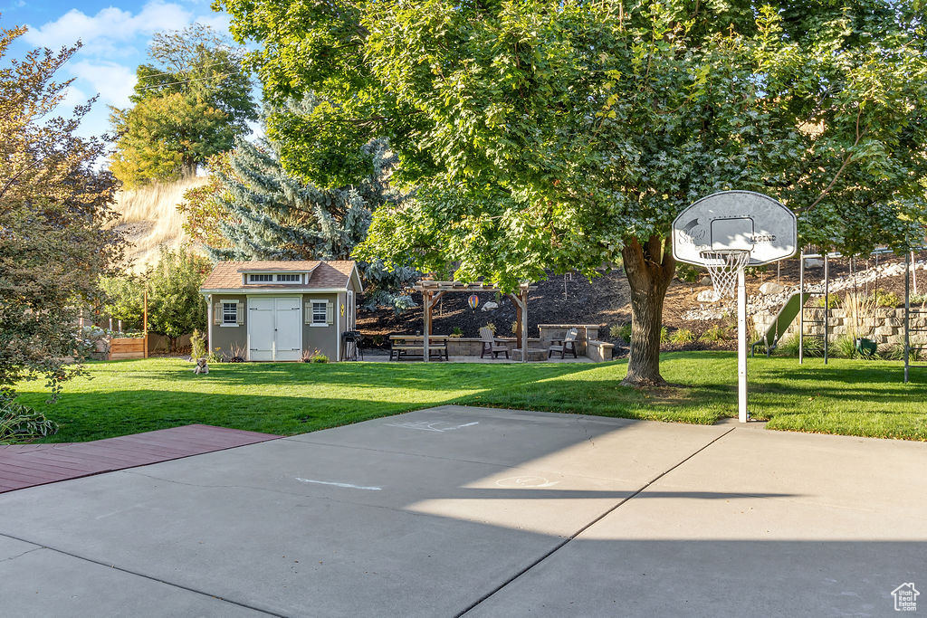 View of patio / terrace featuring basketball hoop and an outdoor structure