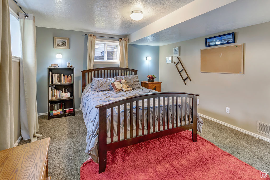 Carpeted bedroom featuring a textured ceiling