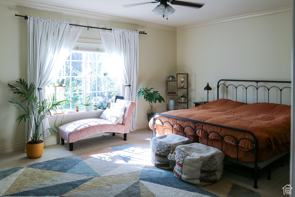 Carpeted bedroom with ceiling fan and ornamental molding