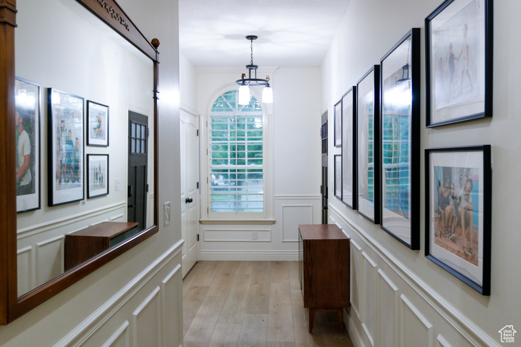 Hallway featuring a notable chandelier and light hardwood / wood-style floors