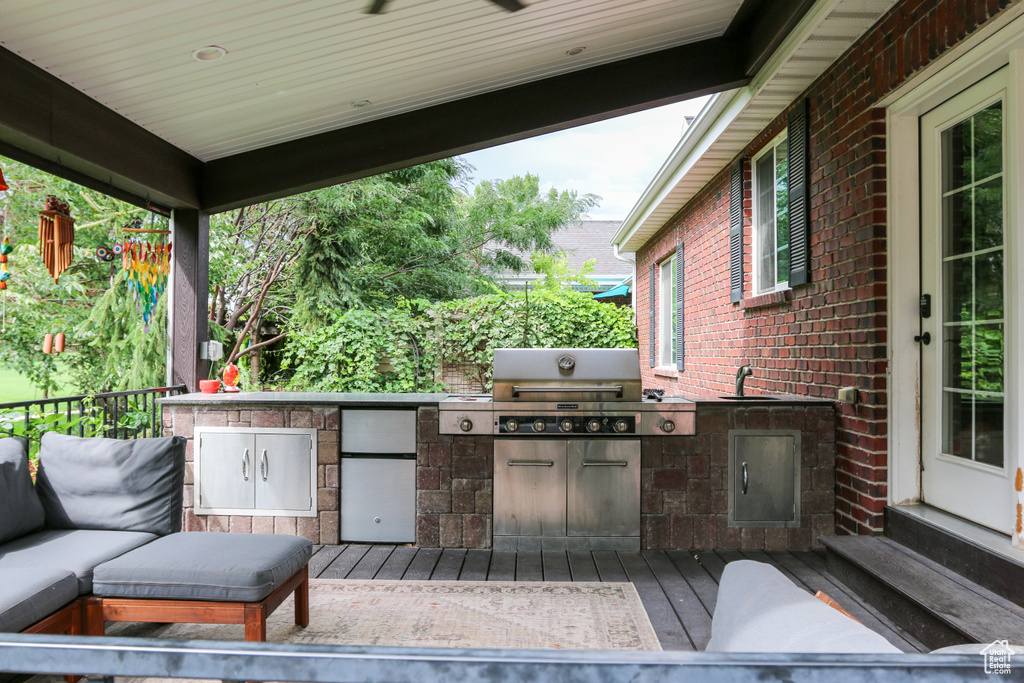 View of patio / terrace with sink, a grill, a wooden deck, and exterior kitchen