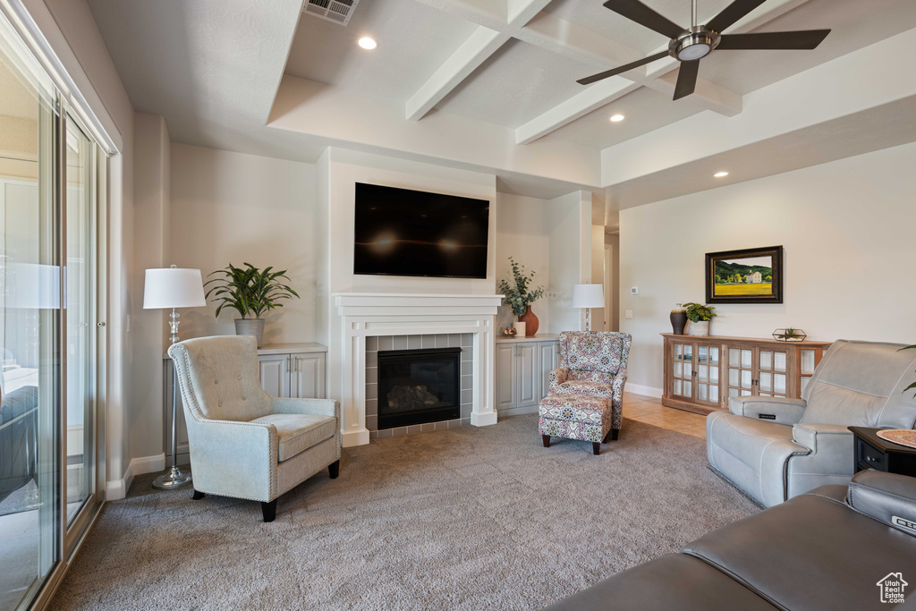 Living room with a fireplace, beamed ceiling, carpet, and ceiling fan