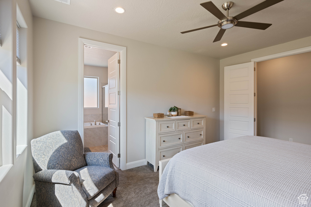 Carpeted bedroom with ceiling fan and ensuite bath