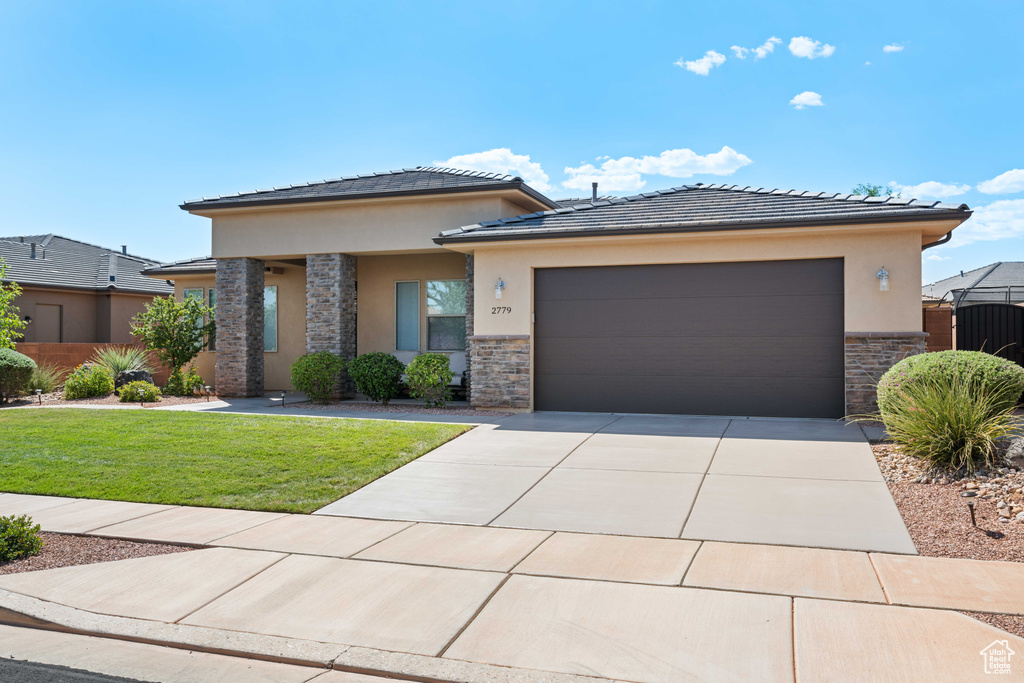 Prairie-style house featuring a front yard and a garage