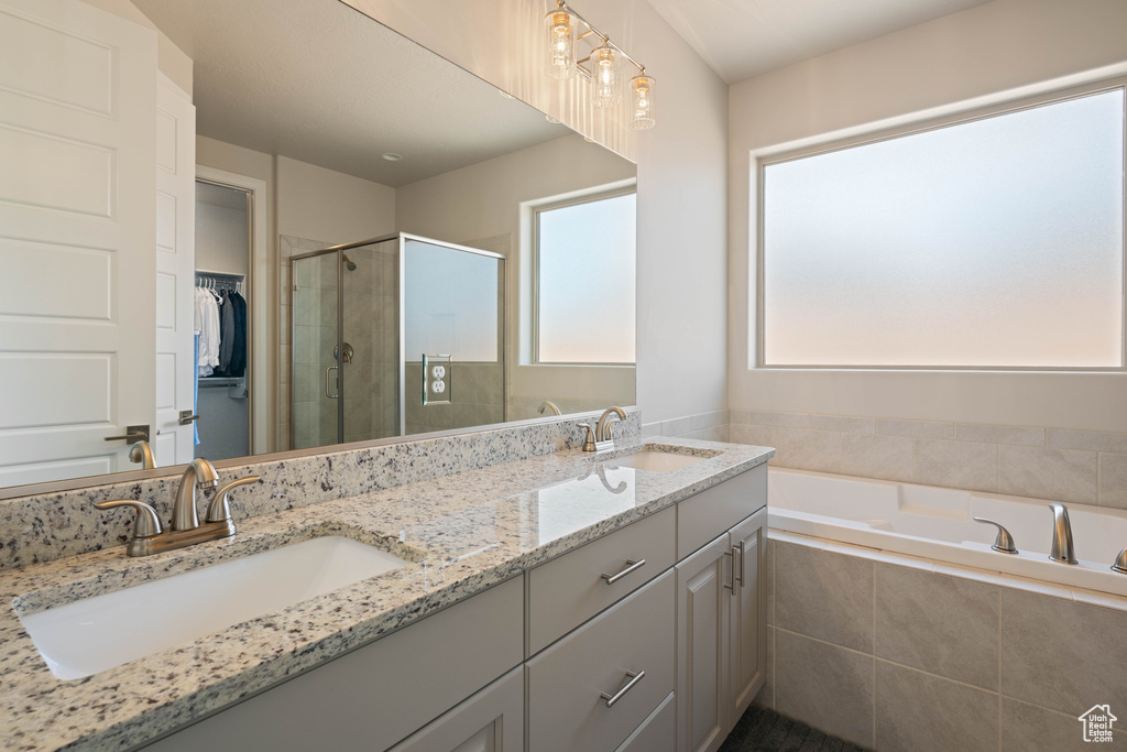 Bathroom featuring vanity and separate shower and tub