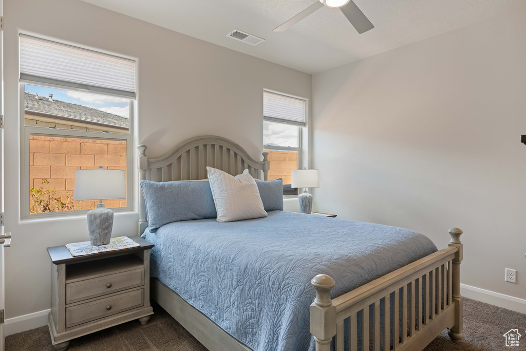 Bedroom featuring ceiling fan and dark carpet