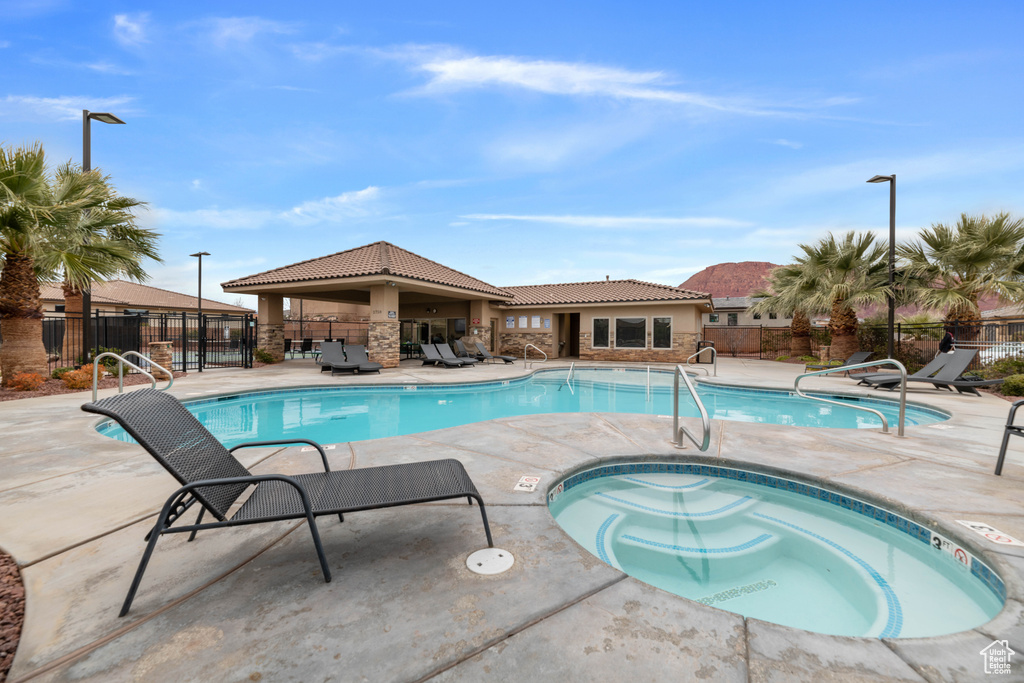 View of pool with a patio area and a hot tub