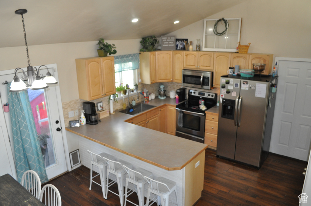 Kitchen featuring pendant lighting, stainless steel appliances, sink, and kitchen peninsula