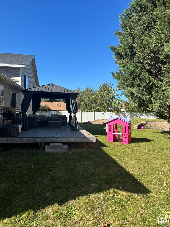 View of yard featuring a gazebo, a storage unit, and a wooden deck