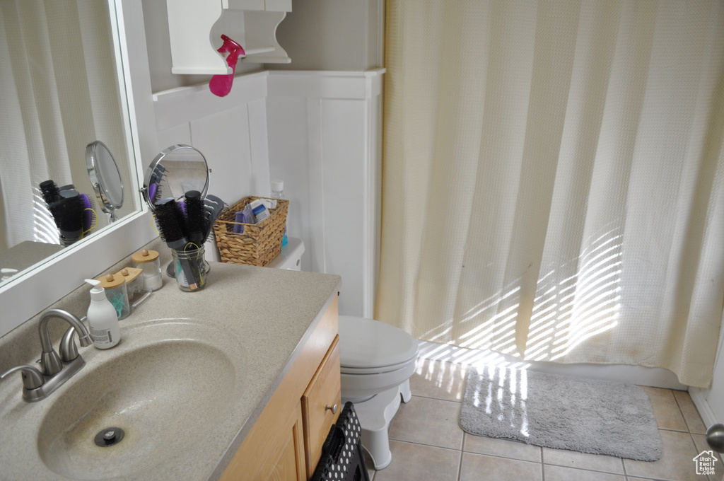 Bathroom with vanity, toilet, and tile patterned floors