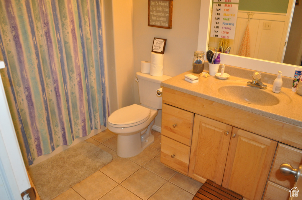 Bathroom featuring vanity, tile patterned flooring, toilet, and a shower with shower curtain