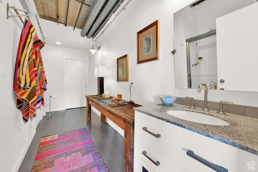 Interior space with concrete floors, a shower with door, and vanity