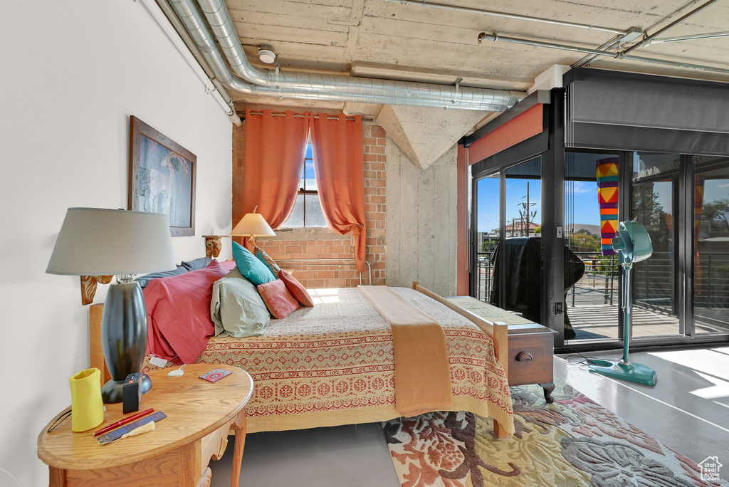 Bedroom featuring access to exterior and concrete floors