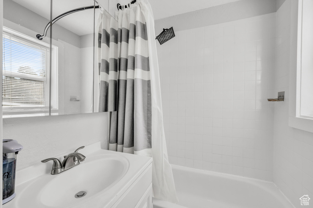 Bathroom featuring shower / tub combo with curtain and vanity