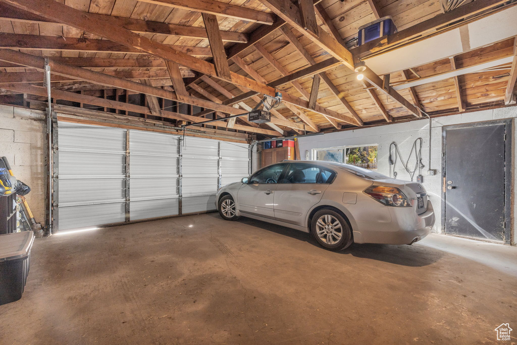 Garage with a garage door opener and wooden ceiling